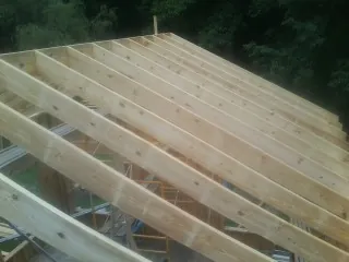 New roof rafters set over an addition before sheathing in Oceanside