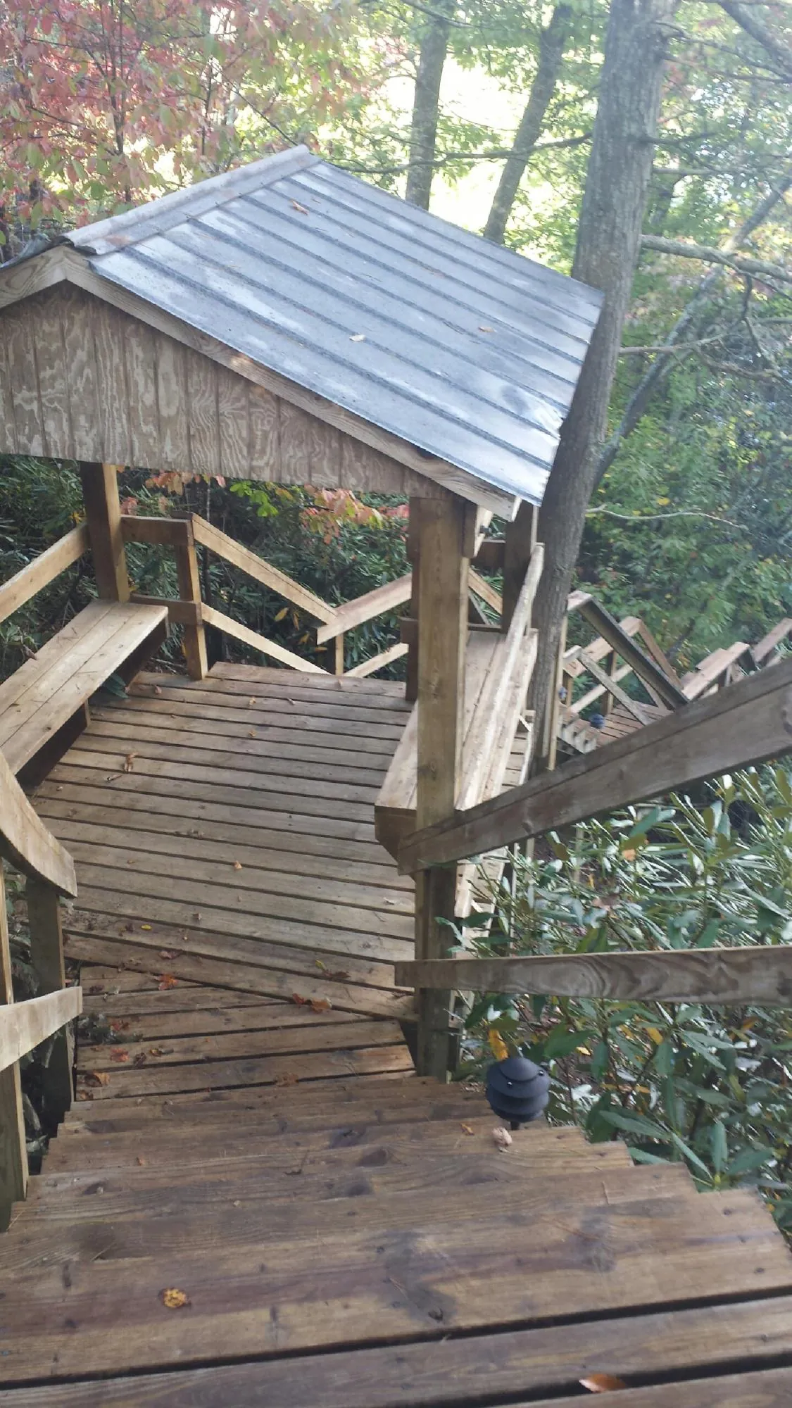 Metal roofed shelter over wooden steps on a wooded walkway — Skylight Repair & Installation work by our crew in Oceanside